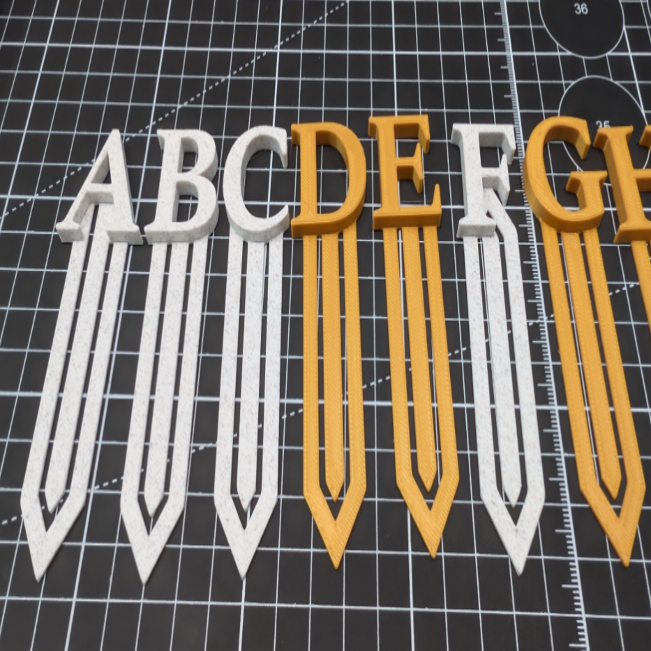 Alphabet letters 'A' to 'G' on a cutting mat with grid lines