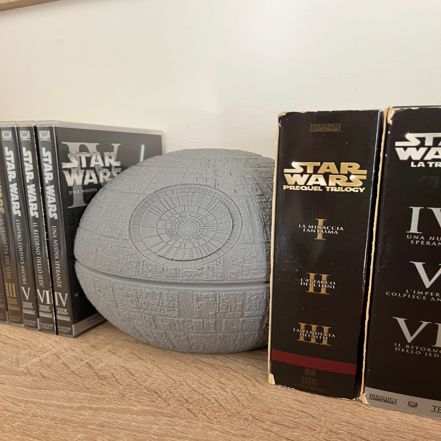 Star Wars Death Star model on a shelf with movie boxes