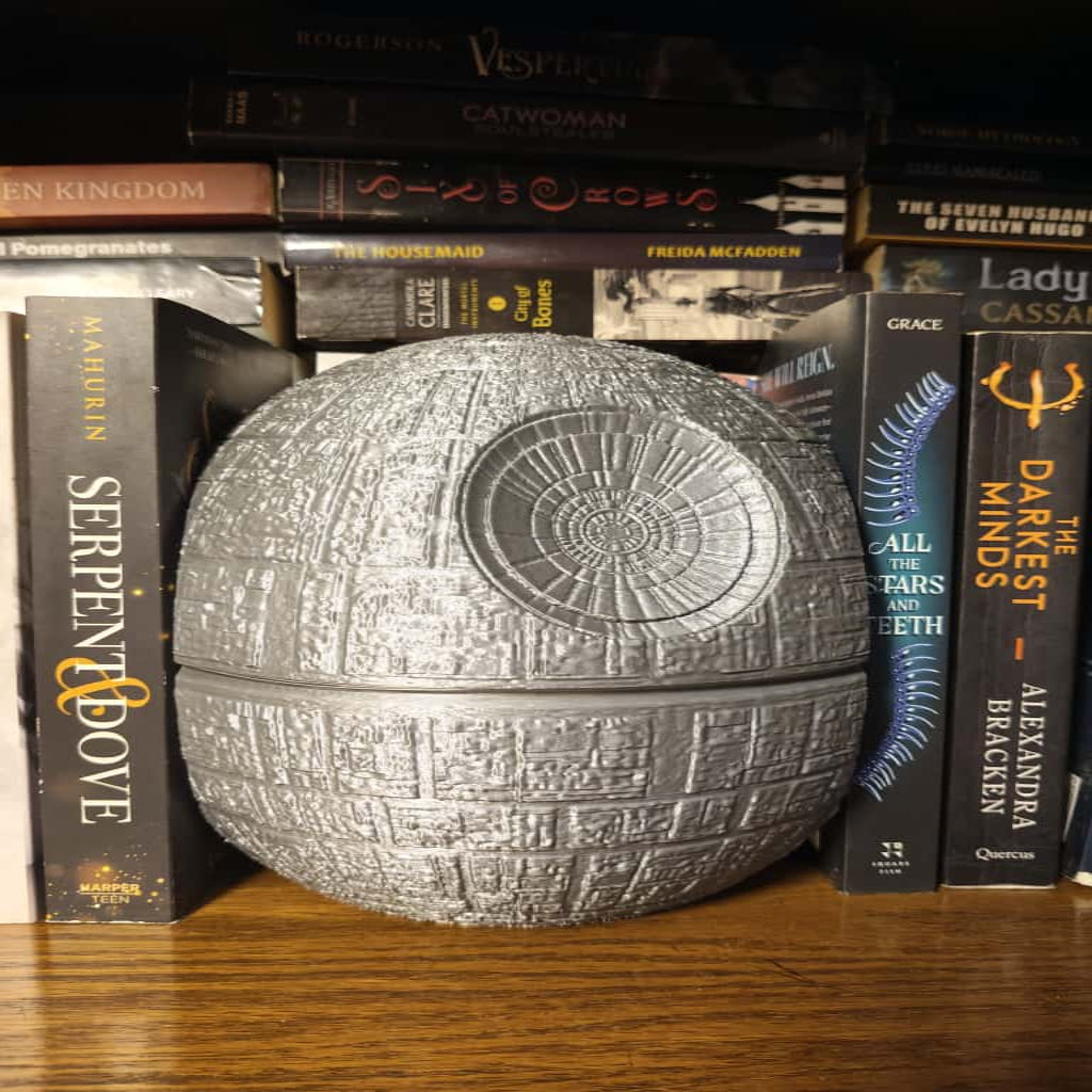 Decorative Death Star model on a shelf with books