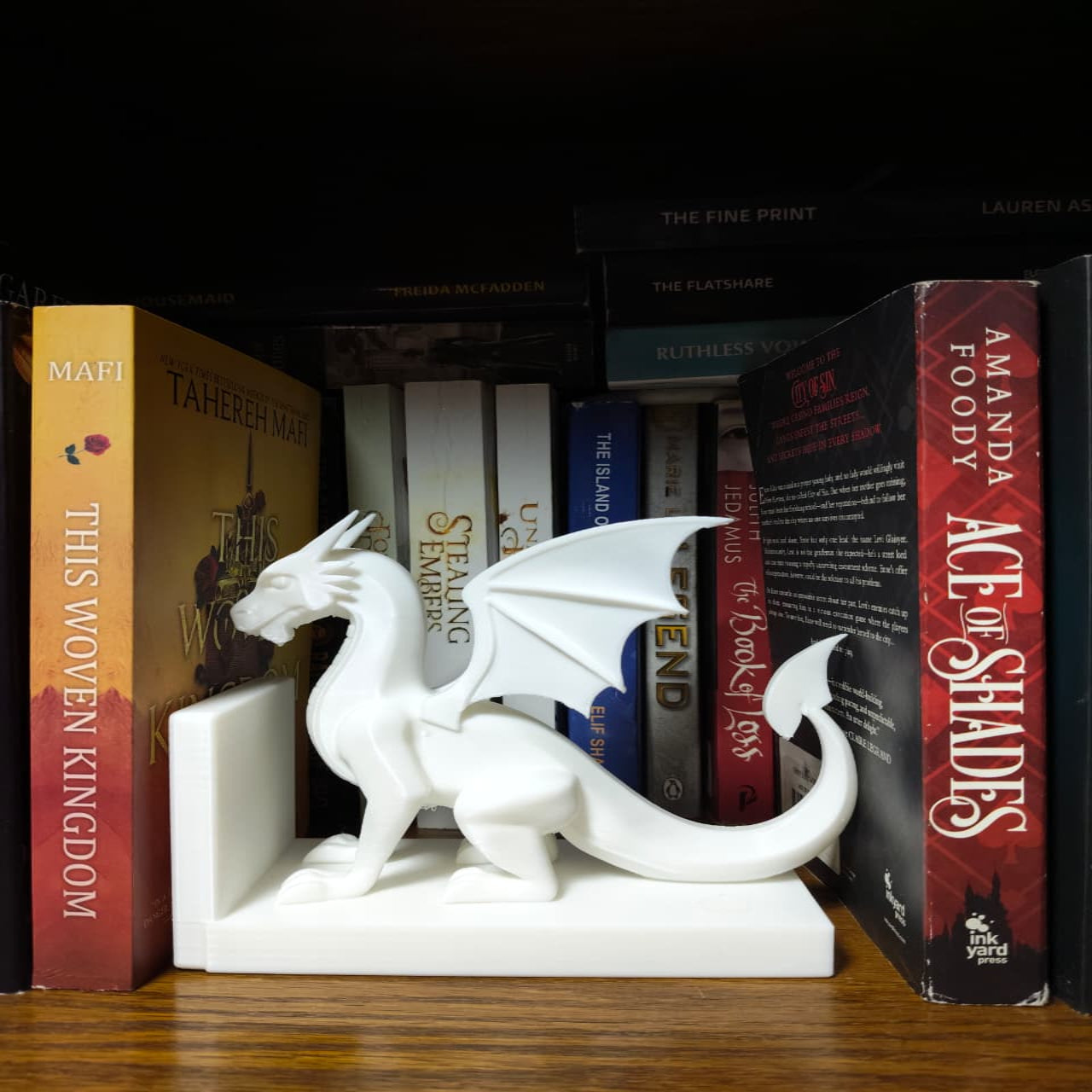 White dragon bookend on a shelf with books