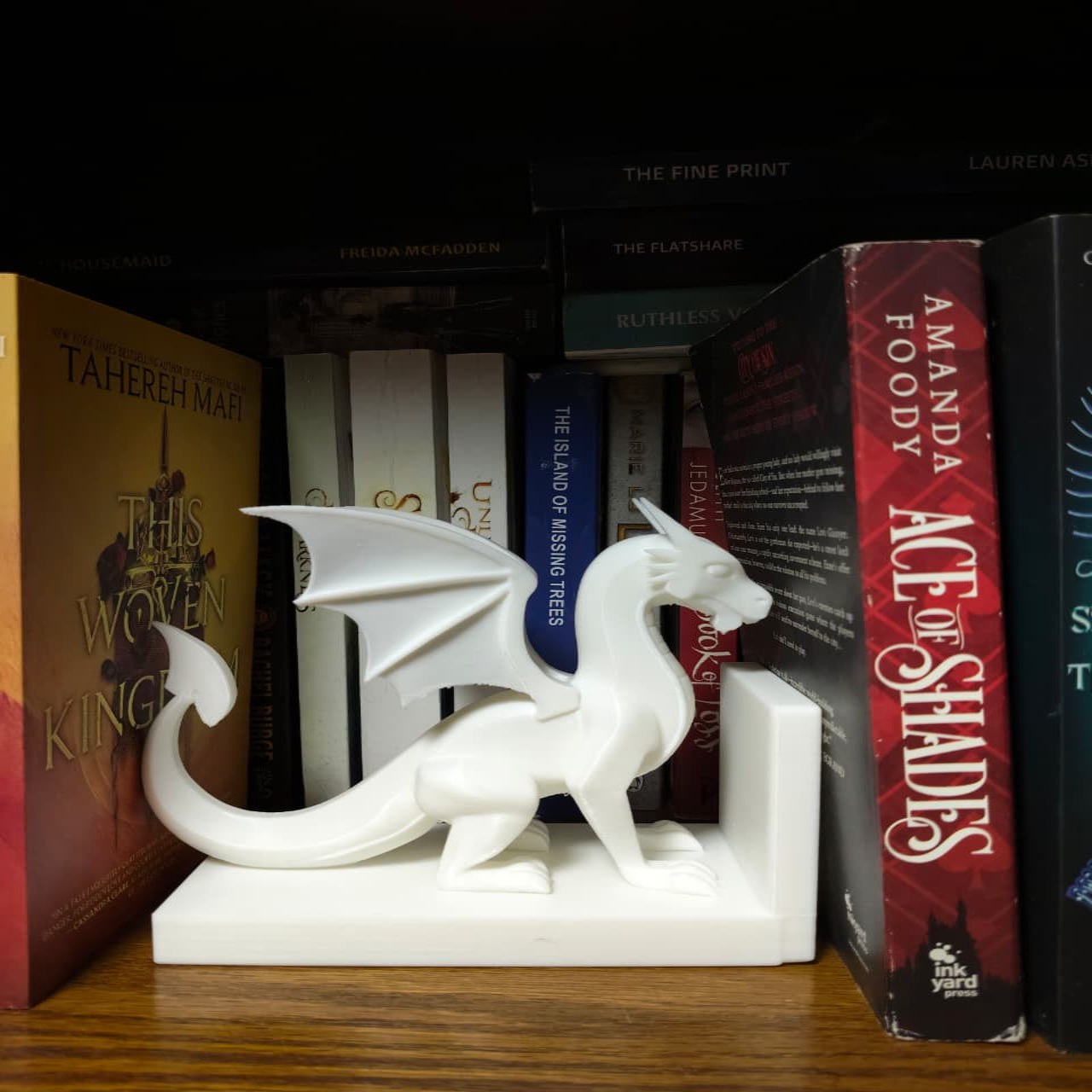 White dragon bookend on a shelf with books