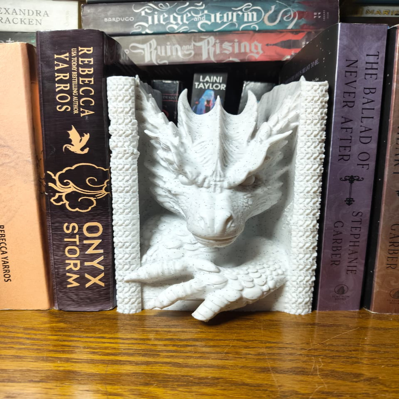 White dragon bookend among books on a wooden surface