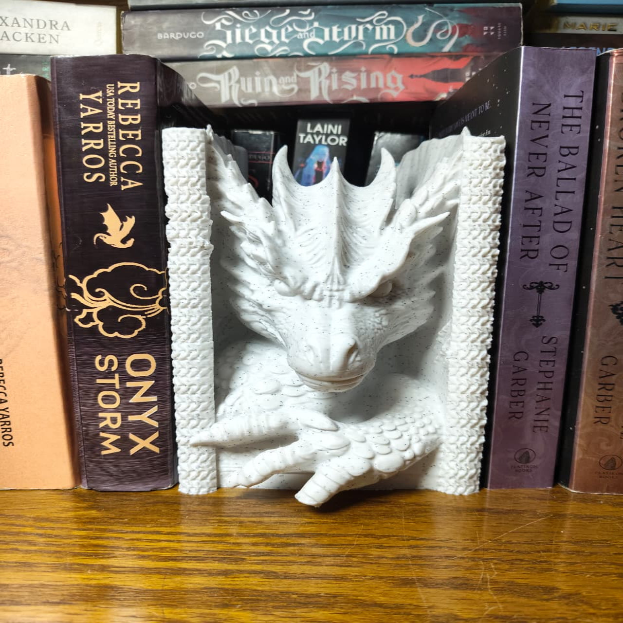 White dragon bookend among books on a wooden shelf