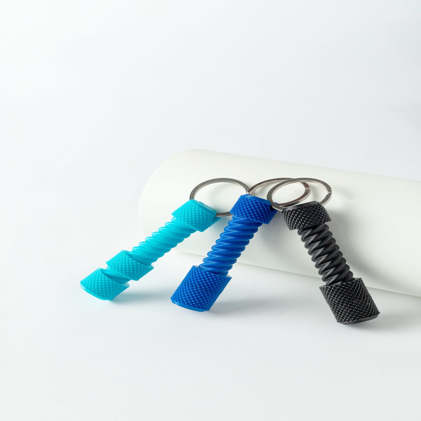 Three Screw Fidget Keychains placed upright against a white background, colors include blue, black, and green.