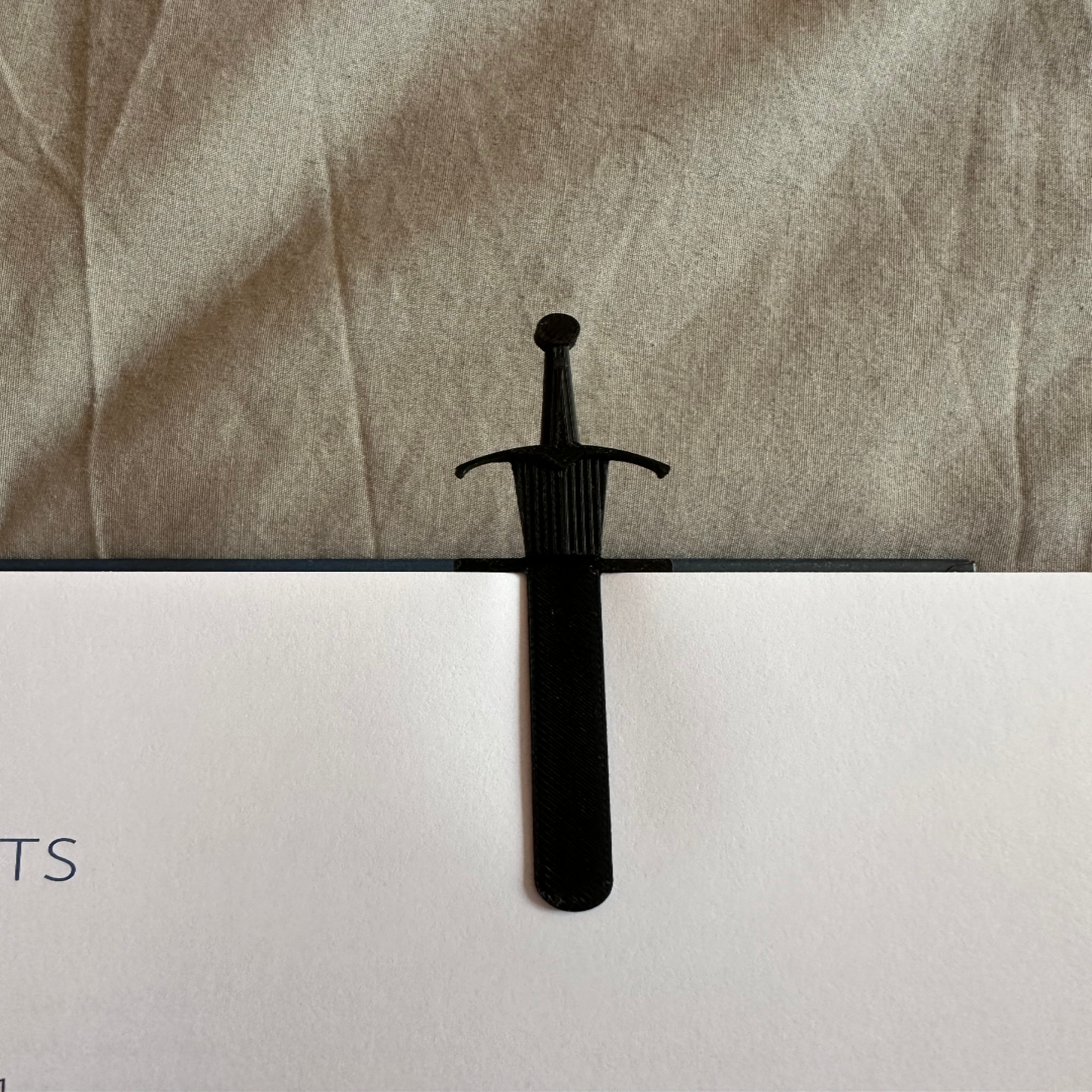Black sword on a textured surface with a blurred background