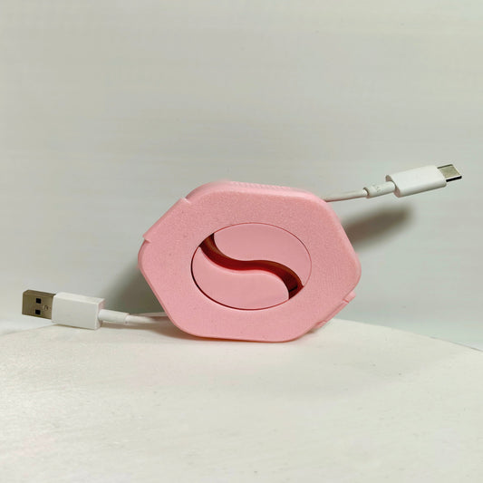 Pink retractable cable with USB connector on a light gray background