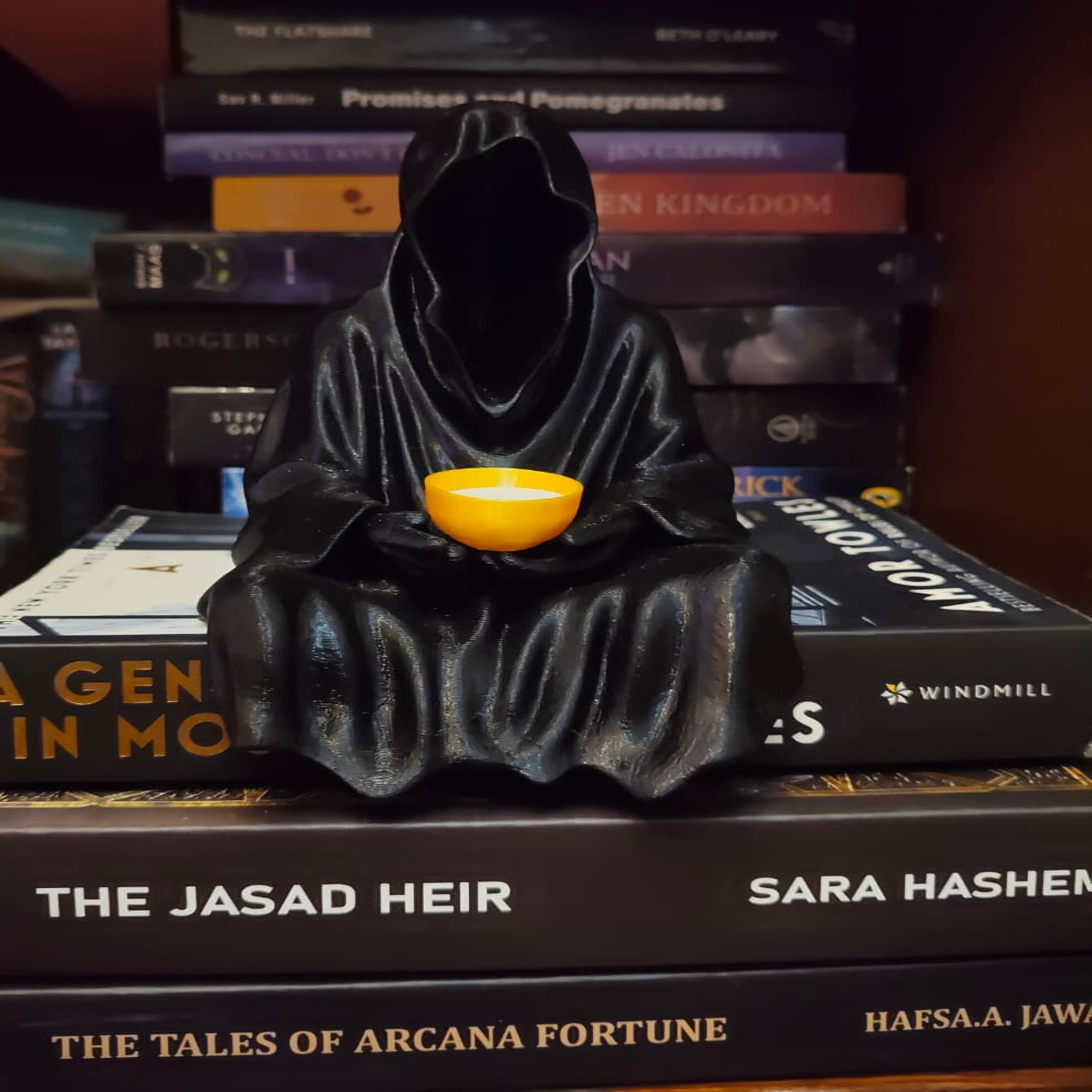 Grim Reaper figurine with a yellow ball on books
