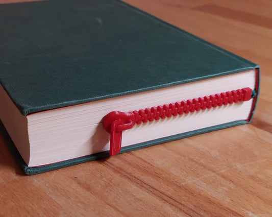 Green book with a red zipper on a wooden surface