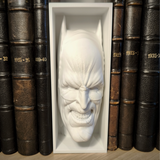 White mask of a superhero face in a white box surrounded by old books.
