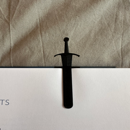 Black sword on a textured surface with a blurred background