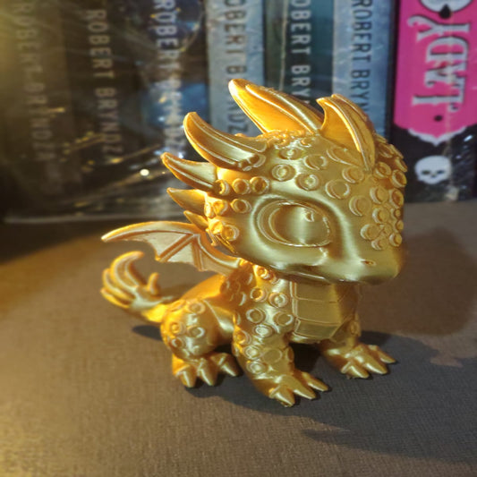 Gold dragon figurine in front of books with visible branding