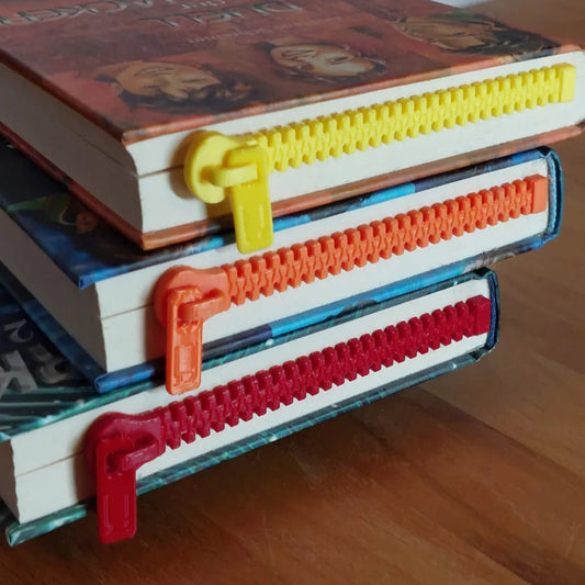 Colorful plastic bookends on a stack of books with a wooden surface background